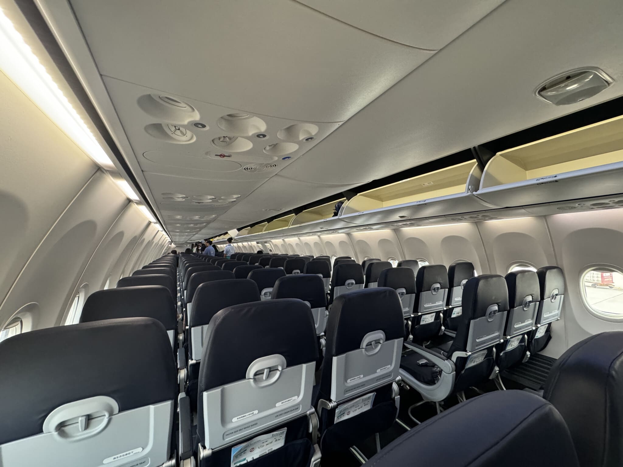 Aircraft cabin overhead panels, open luggage bins and seat backs