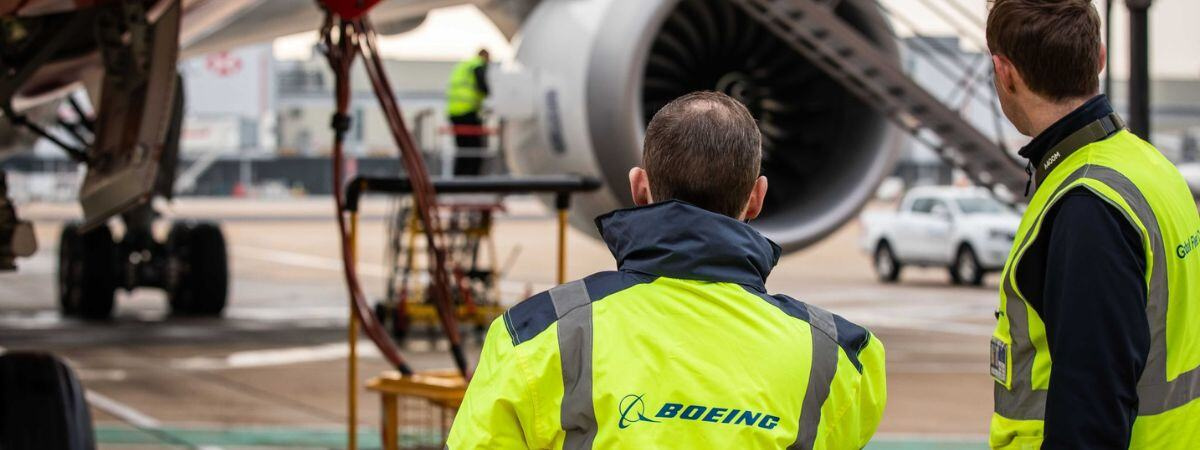 Aircraft maintenance team beside an aircraft engine