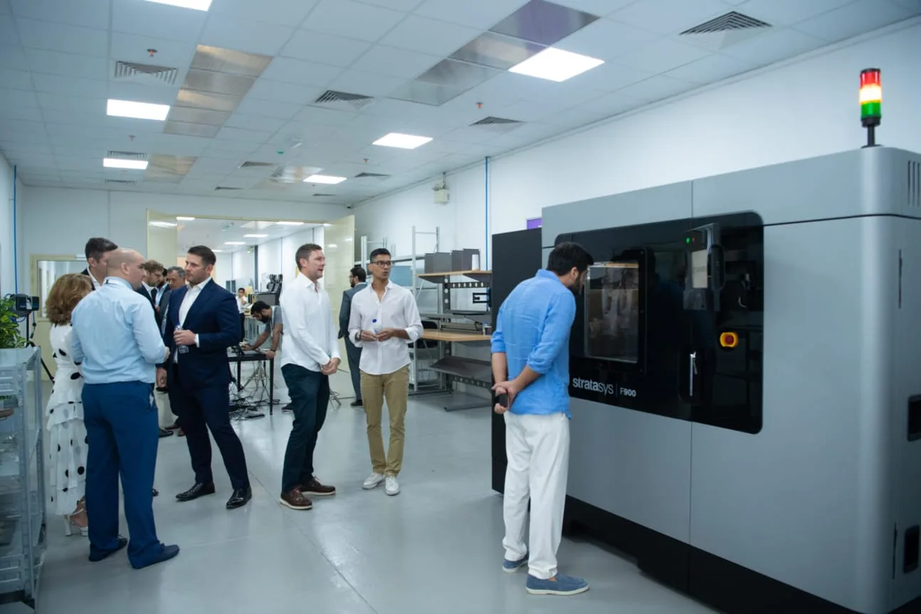 Visitors on the Paradigm 3D production floor beside the Stratasys F900