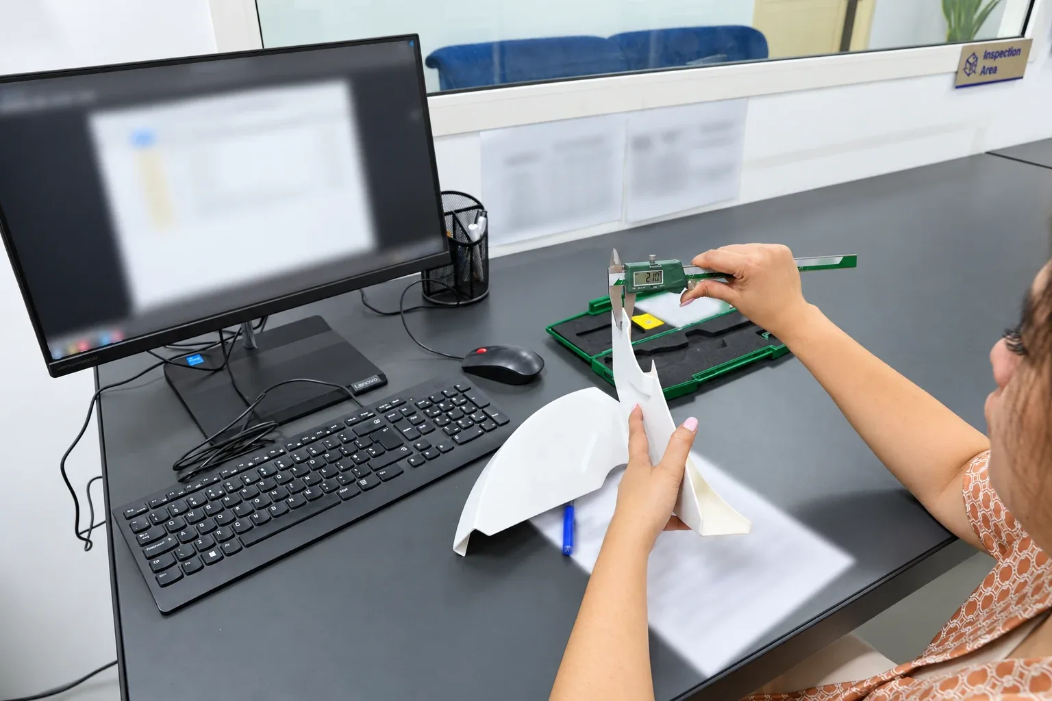 Paradigm 3D technician checking a printed part against its inspection record