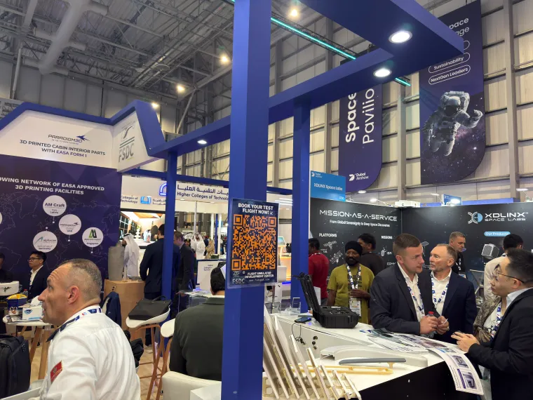 Busy Paradigm 3D stand with visitors gathered at the counter at Dubai Airshow 2025