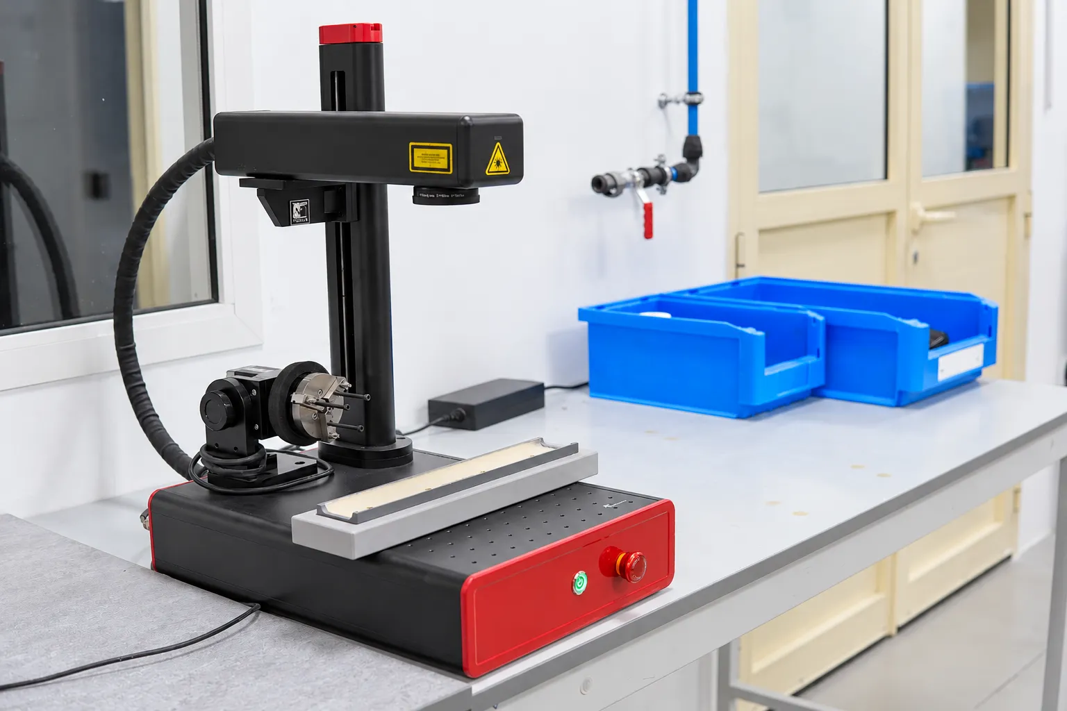 Bench-top marking equipment beside blue storage bins