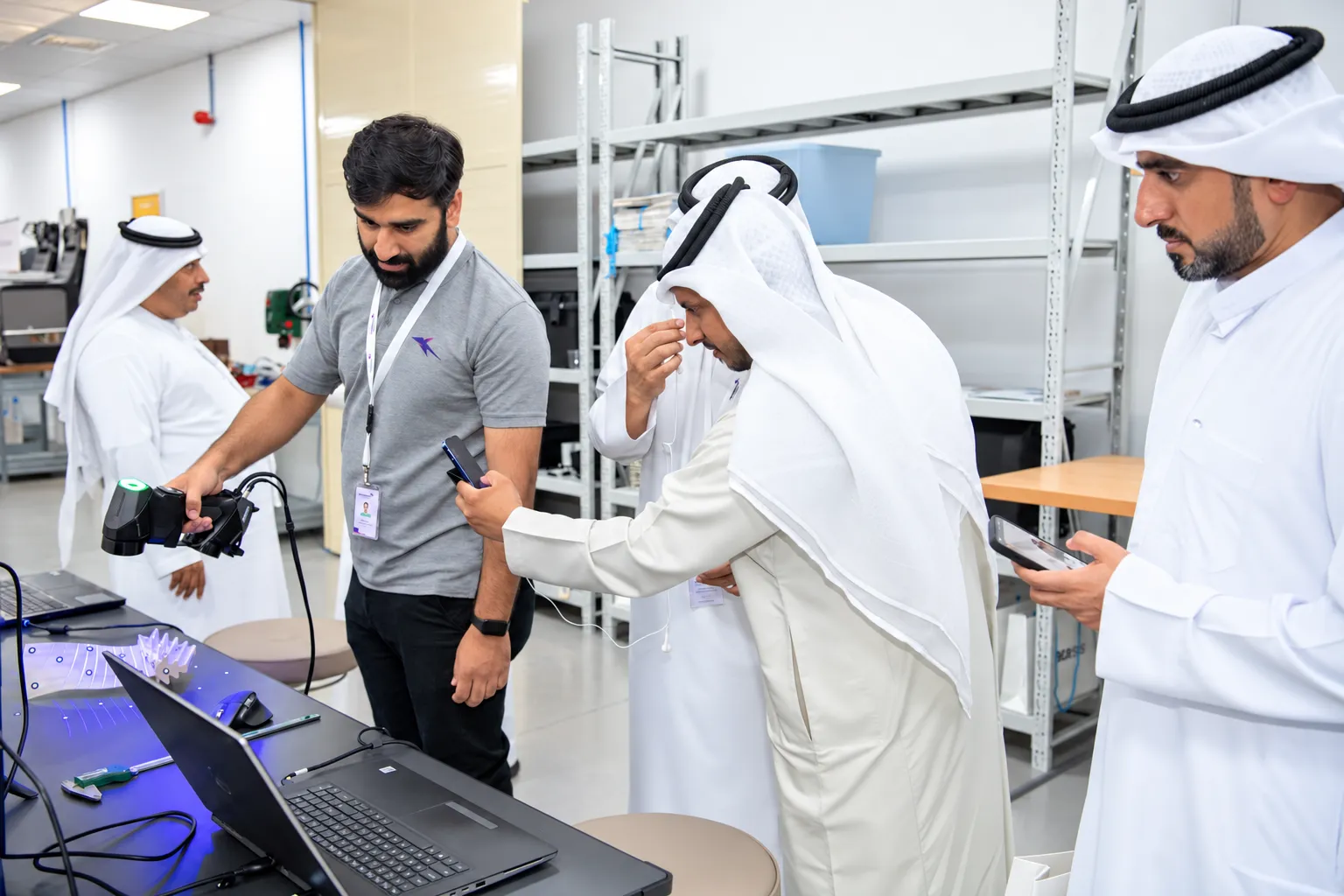 Engineer demonstrating a handheld 3D scanner to visitors