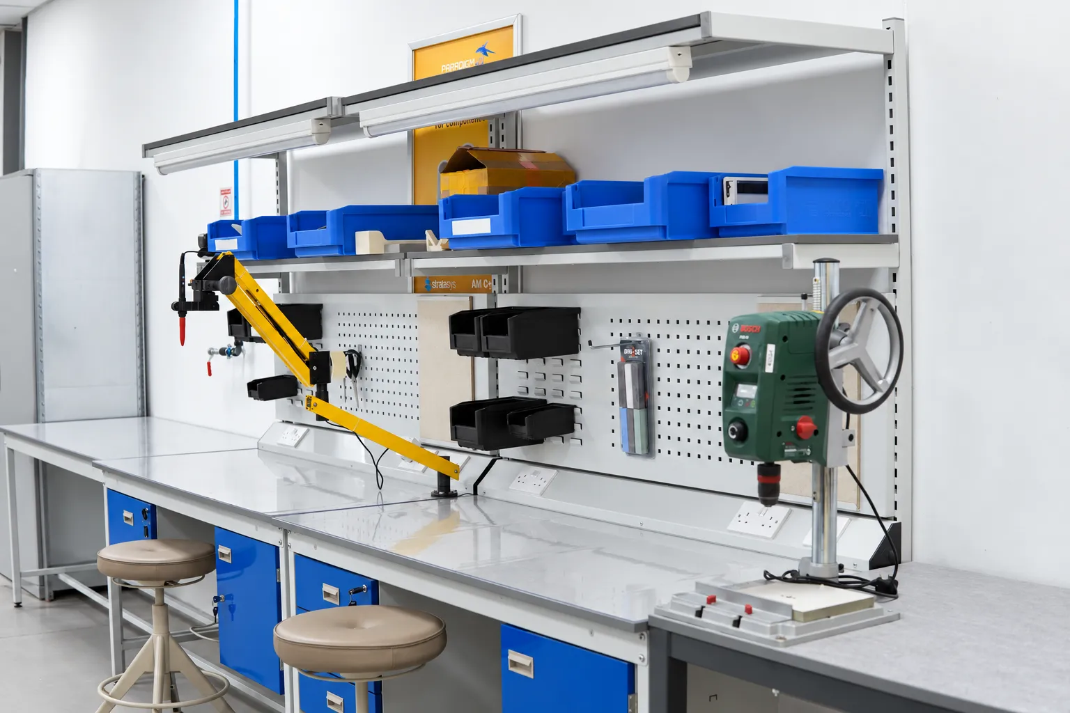 Workshop benches with an articulated tool arm and a drill press