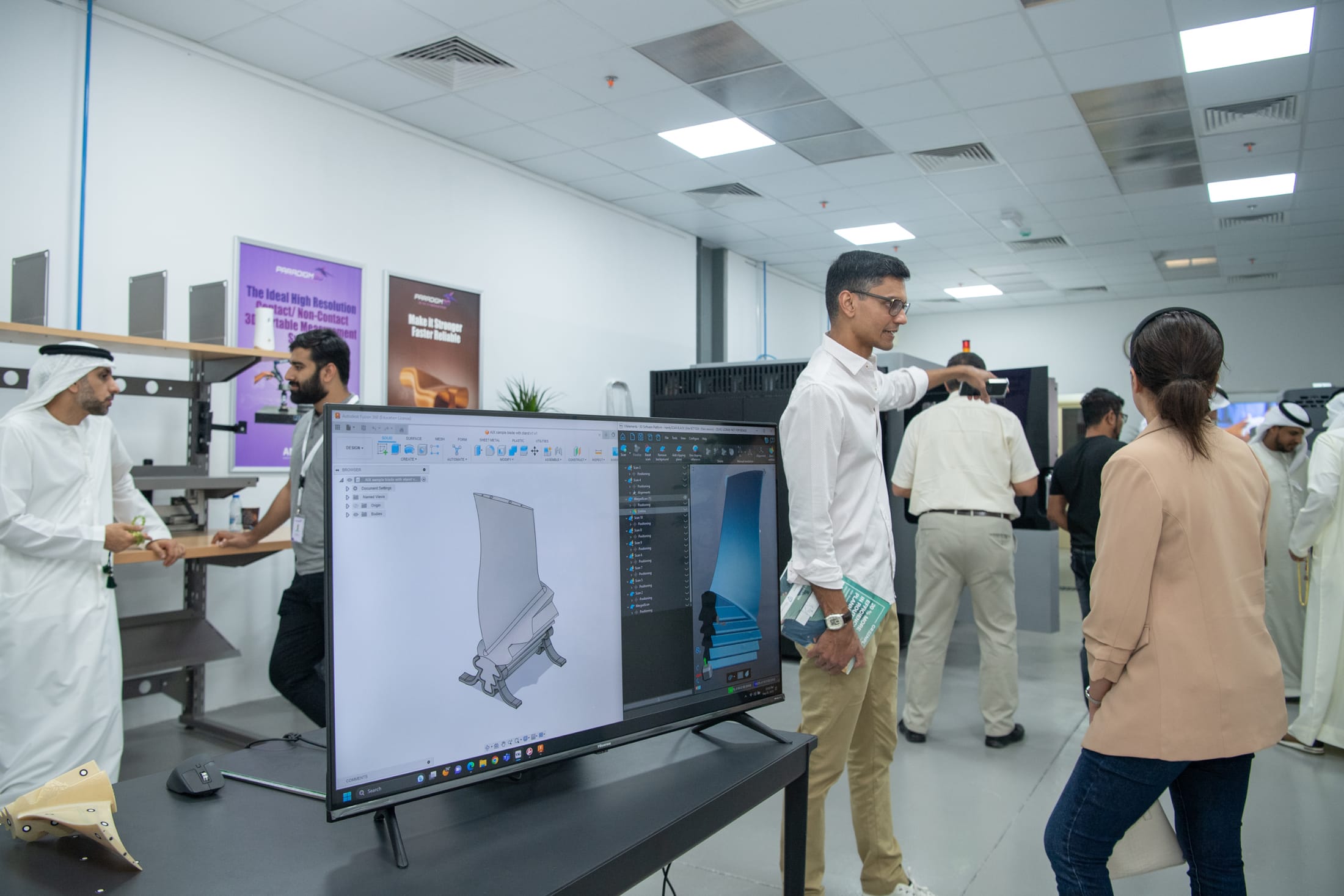 Visitors at the Paradigm 3D engineering area reviewing a CAD model on screen